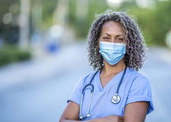 一名非裔美国护士的肖像，在COVID-19爆发期间戴着防护口罩，以避免细菌传播.